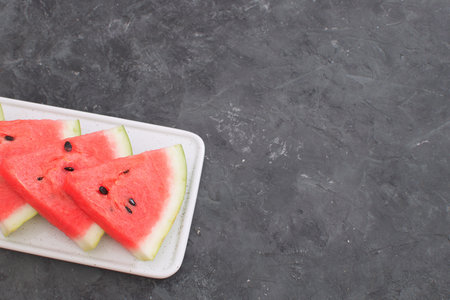Fresh red watermelon slices Isolated black concrete background Selective focus Copy space Perspective Summer concept Minimal pictureの写真素材