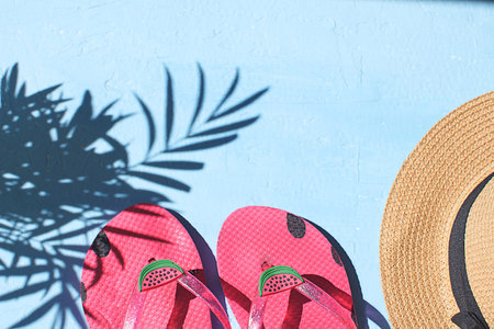Summer season Vacation concept Flay lay Flip flops Straw hat light blue background Top view Copy...