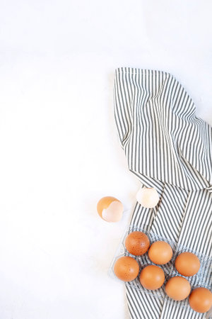 Pastry cooking minimal concept - raw uncooked eggs on Crumpled Striped Napkin, concrete white background. Top view, Flat lay, Copy space.の写真素材