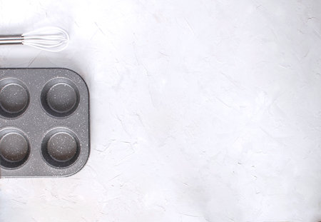 Bakery concept. Muffin tin Kitchen utensils Whisk. White background, Top view, Copy space, Flat lay. Minimal pictureの写真素材