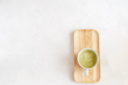 Healthy coffee alternative - matcha latte in white  on wooden tray, top view