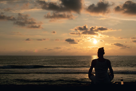Tropical beach paradise - young man silhouette, hipster enjoying sunset on the ocean, meditationの写真素材