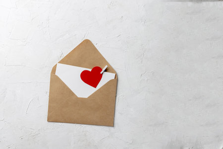 Valentines day minimal concept, hanmade gift - craft envelope, blank love note with clipped red...