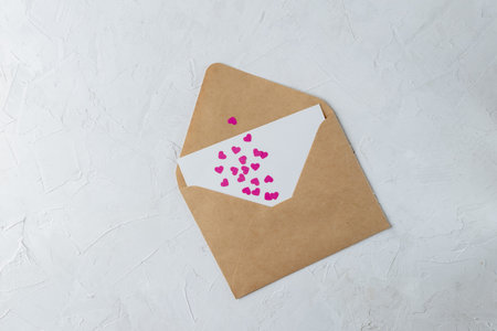 Valentines day minimal concept, hanmade gift - craft envelope with blank nore, pink and white paper...