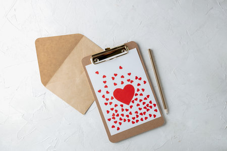 Valentines day minimal concept mockup, blogger workspace - clipboard with blank paper, red paper hearts heart on graybackgroundの写真素材
