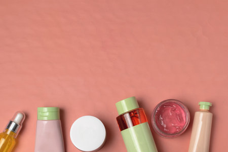 Skin care beauty facial poducts flat lay - face mask, cream, serum, silicone spatula, living coral background, copy spaceの写真素材