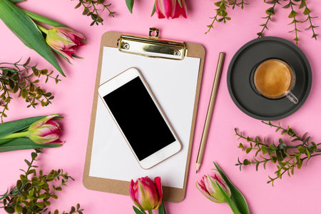 Valentines Womens mothers day concept 8 March Spring, lifestyle blog - pink tulips, clipboard with blank paper, pencil, espresso coffee, smartphone on pink background, copy space, top viewの写真素材