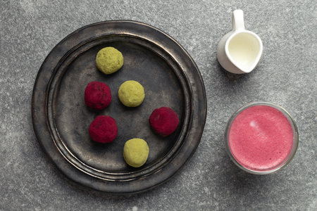 Selective focus on beetroot latte healthy coffee alternative, matcha green tea and pink raspberry beetroot truffles close up, gray background, copy space - gourmet dessert, top viewの写真素材