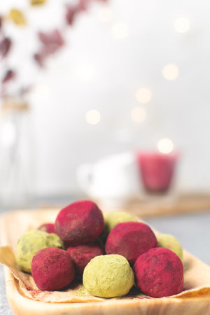 Selective focus on matcha green tea and pink raspberry beetroot truffles close up, white background, copy space - gourmet healthy dessert, top view, bokeh backgroundの写真素材