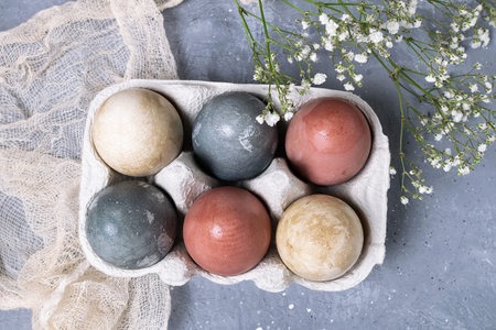 Organic natural easter concept, rustic style - naturally dyed easter eggs in cardboard container,...