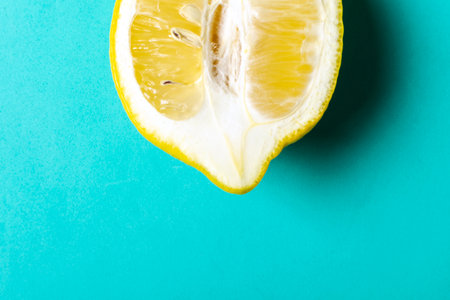Half of ripe lemon on blue background, top view, minimal composition, summer fruit concept, flat lay, pop artの写真素材