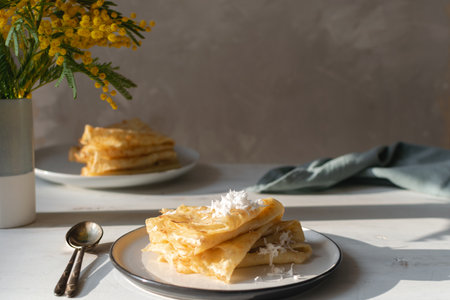 Morning, breakfast - traditional russian blini pancakes, french crepes whipped cream, cast iron green teapot, white wooden table, hard natural sun light, deep shadowsの写真素材
