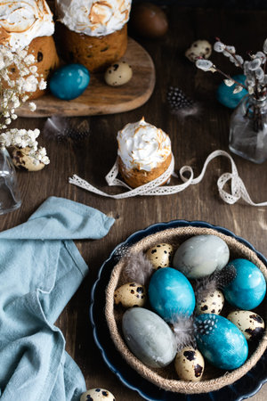 Spring organic easter concept, - naturally dyed easter eggs, quail eggs, feathers, easter cake, dark...