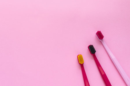 Dental hygiene concept - tooth brushes flat lay, top view, copy space, pink backgroundの写真素材