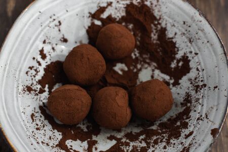 Selective focus on delicious dark chocolate candy truffles with sichuan pepper on dark background, top viewの写真素材