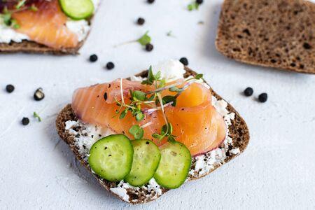Healthy omega 3 breakfast or brunch - rye bread, smoked salmon, avocado, cucumber and microgreensの写真素材