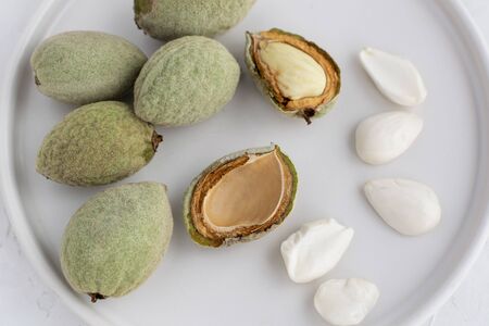 Fresh young green almonds top view, flat lay on white backgroundの写真素材