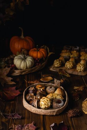 Typical Catalonia, Spain All Saints Day marzipan sweet panellets and roasted chestnuts, autumn leaves on wooden tableの写真素材