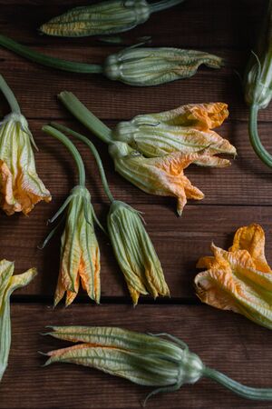 Italian cuisine organic raw zucchini flowers,on rustic wooden tableの写真素材