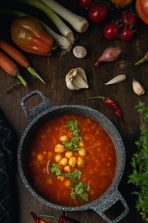 Vegetables, lentils and chickpeas vegetarian or vegan soup, source of protein, on brown wooden tableの写真素材