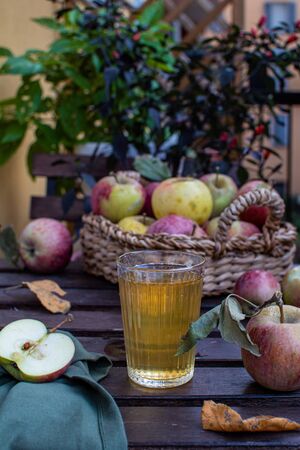 Organic apple juice or sider with fresh ripe apples on rustic wooden backgroundの写真素材