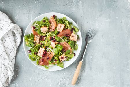 Healthy eating, grilled salmon, arugula, grapefruit and pomegranate on gray table, top view, copy spaceの写真素材
