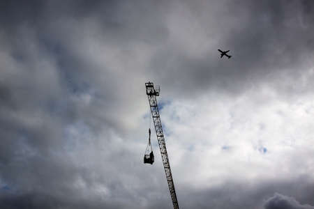 Worker swings crane basket in the skyの写真素材