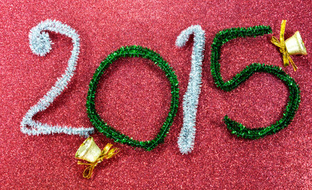 new year figures on red background and yellow bell