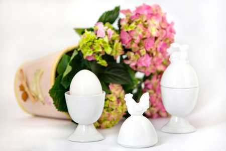White containers for eggs on background of flower