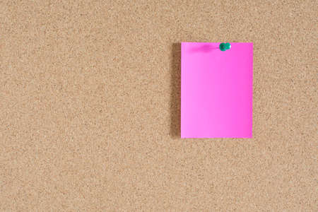 Pink note paper on cork board backgroundの写真素材