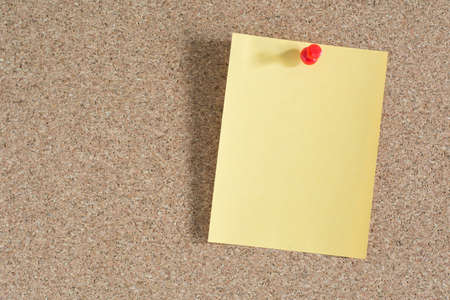 Yellow note paper on cork board backgroundの写真素材