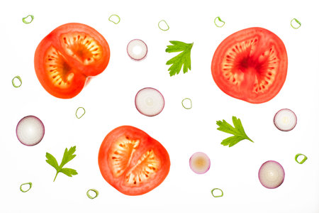 Slices of tomatos, red scallions and parsley leaves as tomato salad ingredians. Backlit on a light...