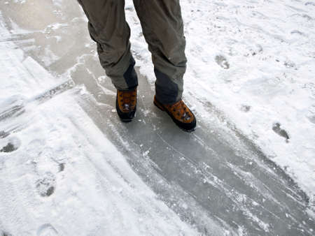 Man in mountain boots on the ice (river, winter)の写真素材