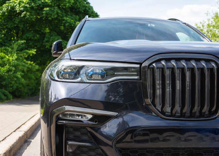 Close-up in front of a new black prestige car, expensive status car SUV, headlights, radiator grille, bumper, hood.の写真素材