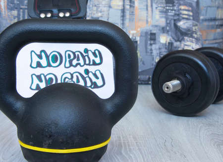 Black gymdumbbell, kettlebell with motivational poster Train hard for active workouts at home. Home workouts, healthy lifestyleの写真素材