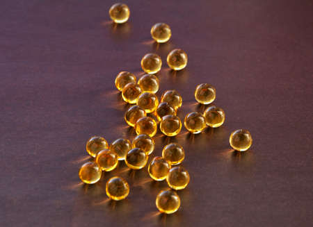 Vitamins fish oil on a brown backgroundの写真素材