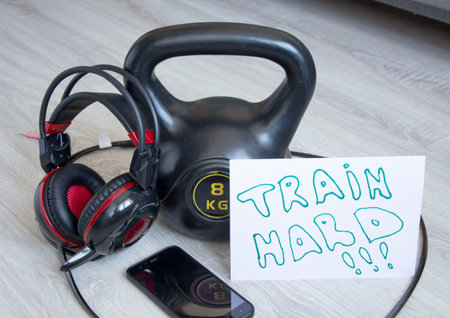 Gym kettlebell with music headphones and motivational poster / Train hard / for active workouts at...