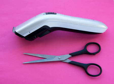 Hair clipper and scissors on pink backgroundの写真素材