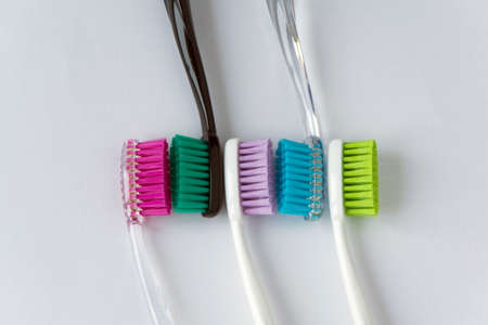 A green juicy strong apple and several colored toothbrushes next to it, on a white backgroundの写真素材