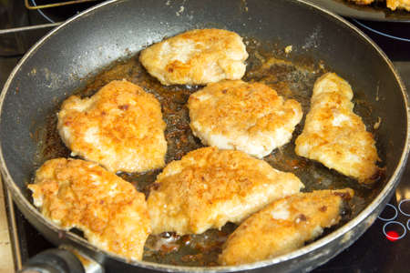 Fried delicious chicken cutlets in a hot frying pan. Home cooking.Top and side viewの写真素材