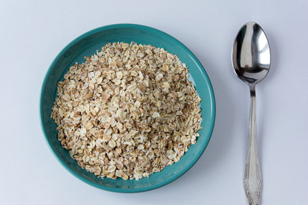 oatmeal in a turquoise plate, green apple and spoon on a white background, healthy breakfast, herculesの写真素材