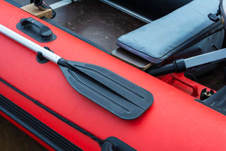 Paddle on board a rubber inflatable boat, red inflatable boat with a paddle, tourism, active lifestyle, fishing.の写真素材