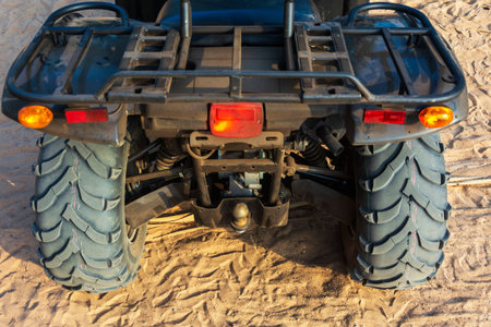 Off-road ATV on the sandy beach of the sea, quad bike rides, active recreation, tourism.