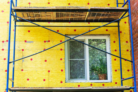 Insulation of the walls of a multi-storey building, construction of a multi-storey building. Thermal insulation of the exterior walls of the house. Thermal insulation materials, mats, plates. The cradle of the lift.の写真素材