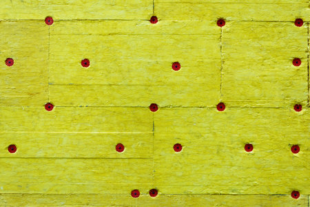 The wall of the house is finished with yellow insulation plates, thermal insulation materials, mats,...