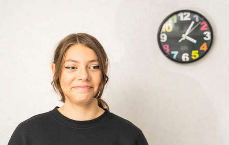 Portrait of a pretty European teenage girl on a light background, smiling, looking at camera. a happy schoolgirl.の写真素材