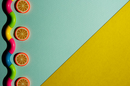 Creative composition on a turquoise-yellow background of orange slices and a wavy snake, waves, a minimalistic concept.の写真素材