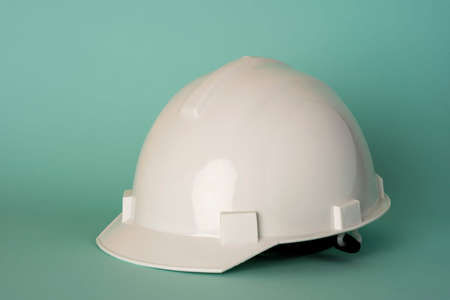 white construction protective helmet on a turquoise background, safety, labor protection.の写真素材