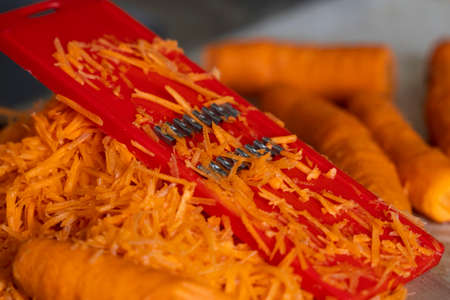 grating carrots on a grater for korean carrots , lifestyle, cooking, healthy eating.の写真素材
