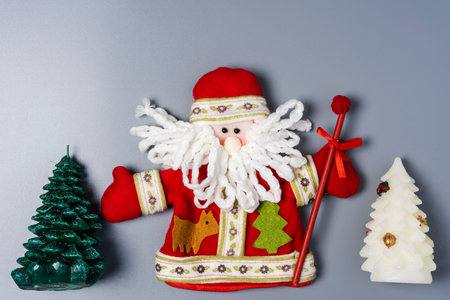 Decorative Santa Claus doll and Christmas tree on a gray background with space to copy. Merry...